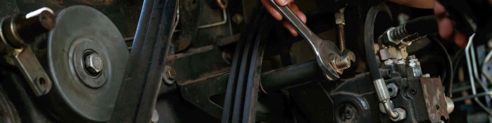 Mechanic troubleshooting a belt drive system