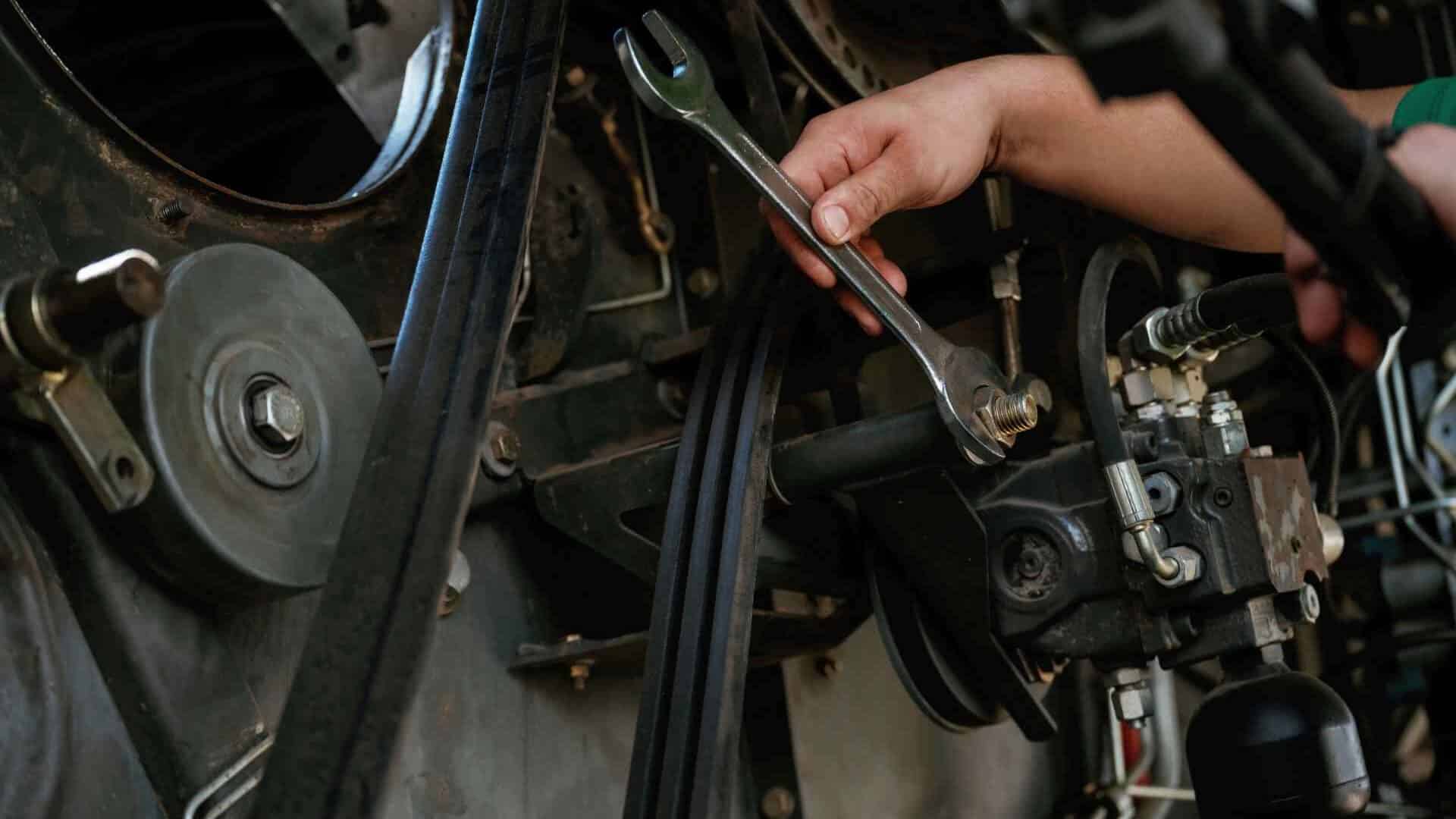 Mechanic troubleshooting a belt drive system