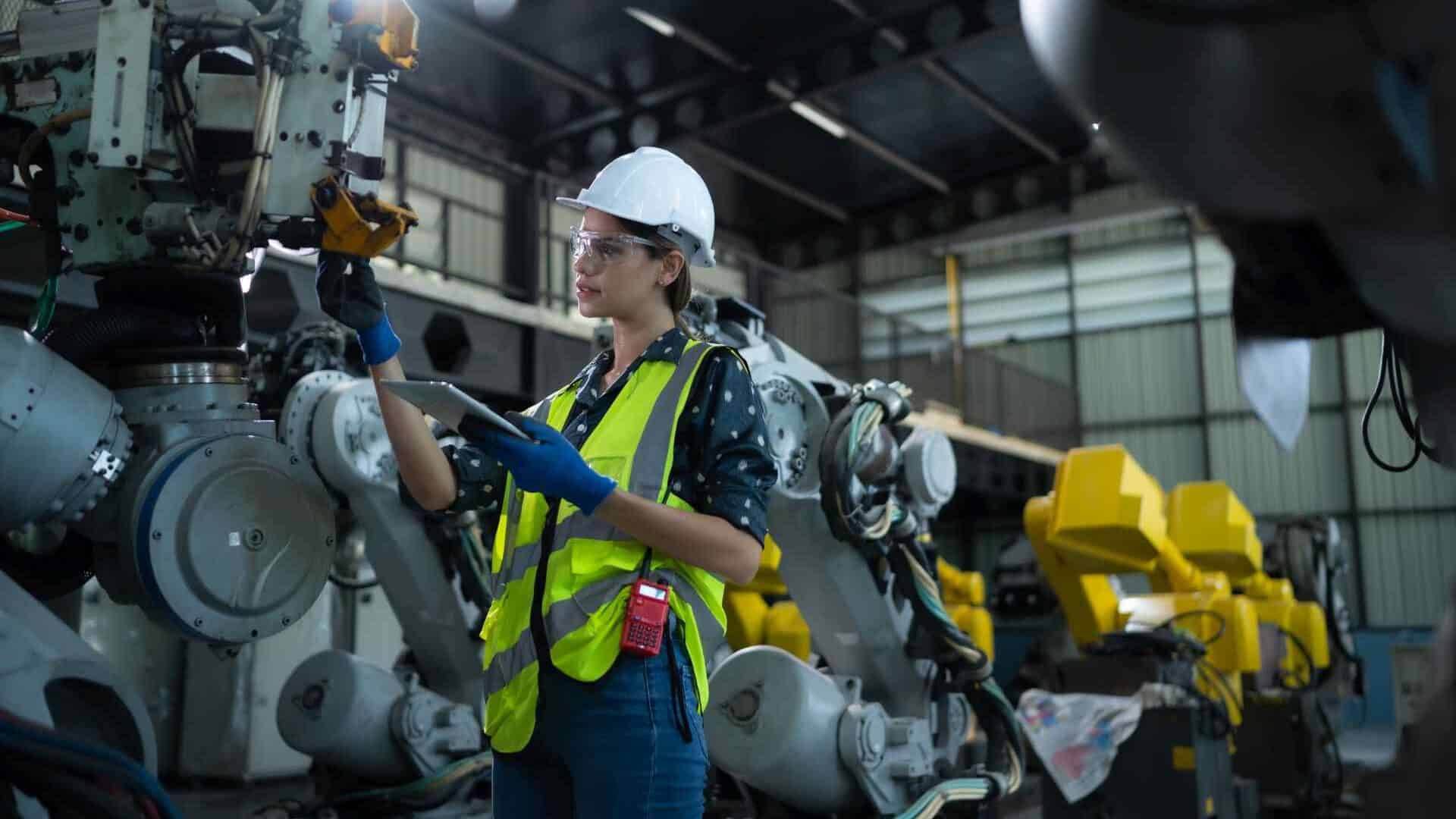 Engineer inspects robotic arm machinery in a factory