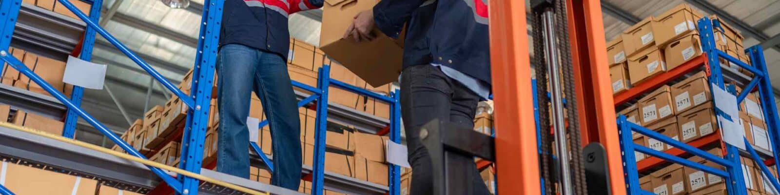 Workers using ergonomic material handling equipment.