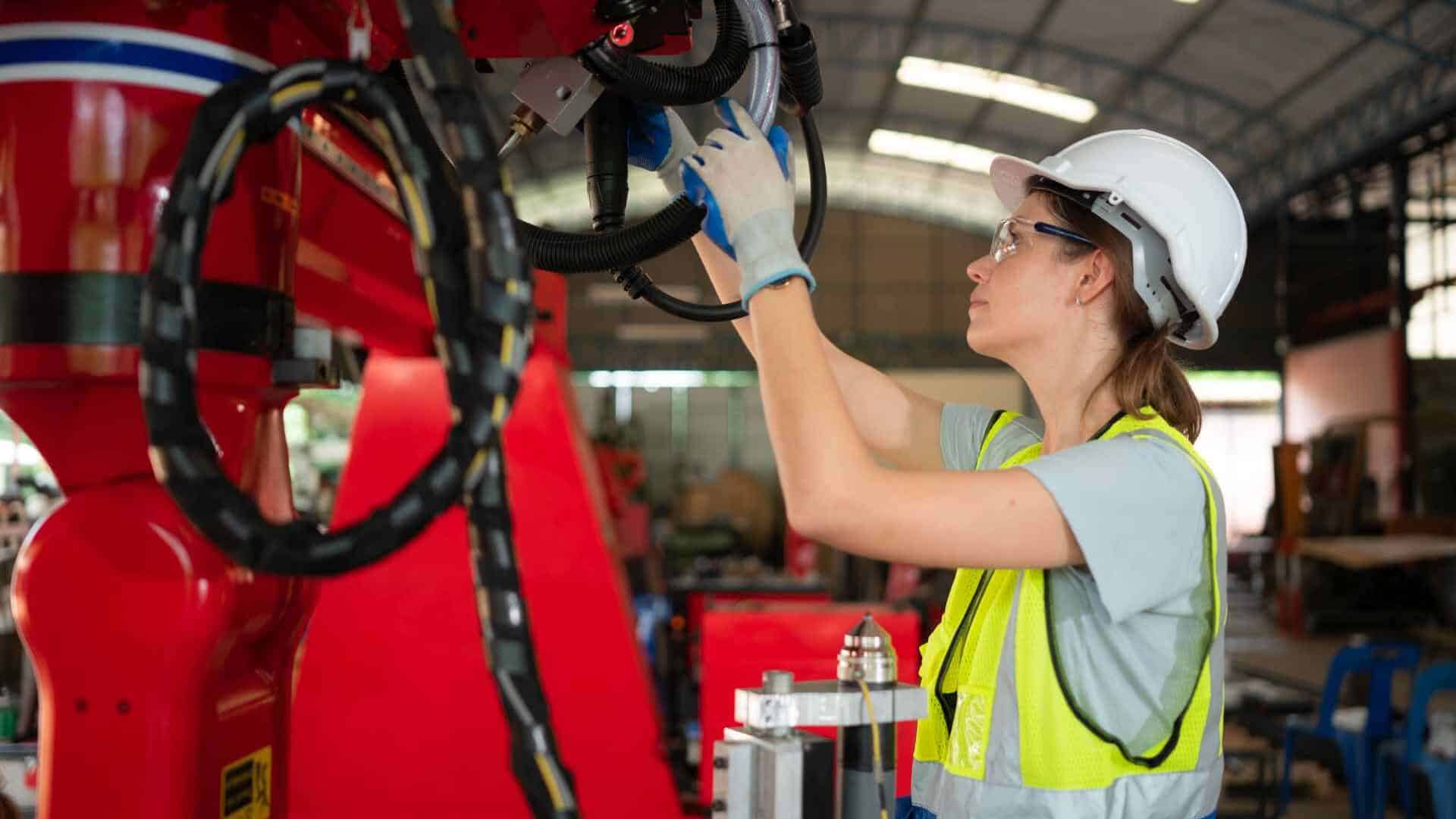 Technician inspecting robotics to prevent equipment breakdown