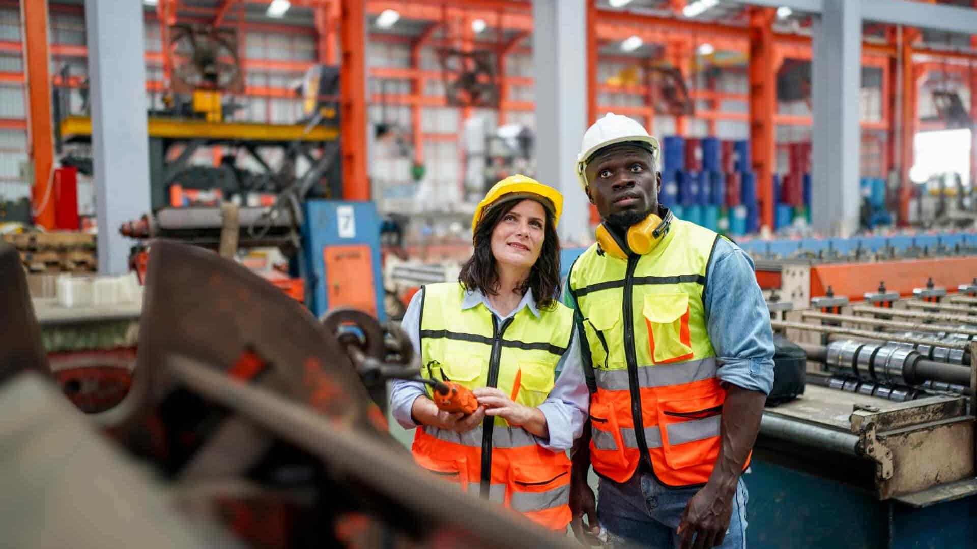 Two industrial workers examining machinery
