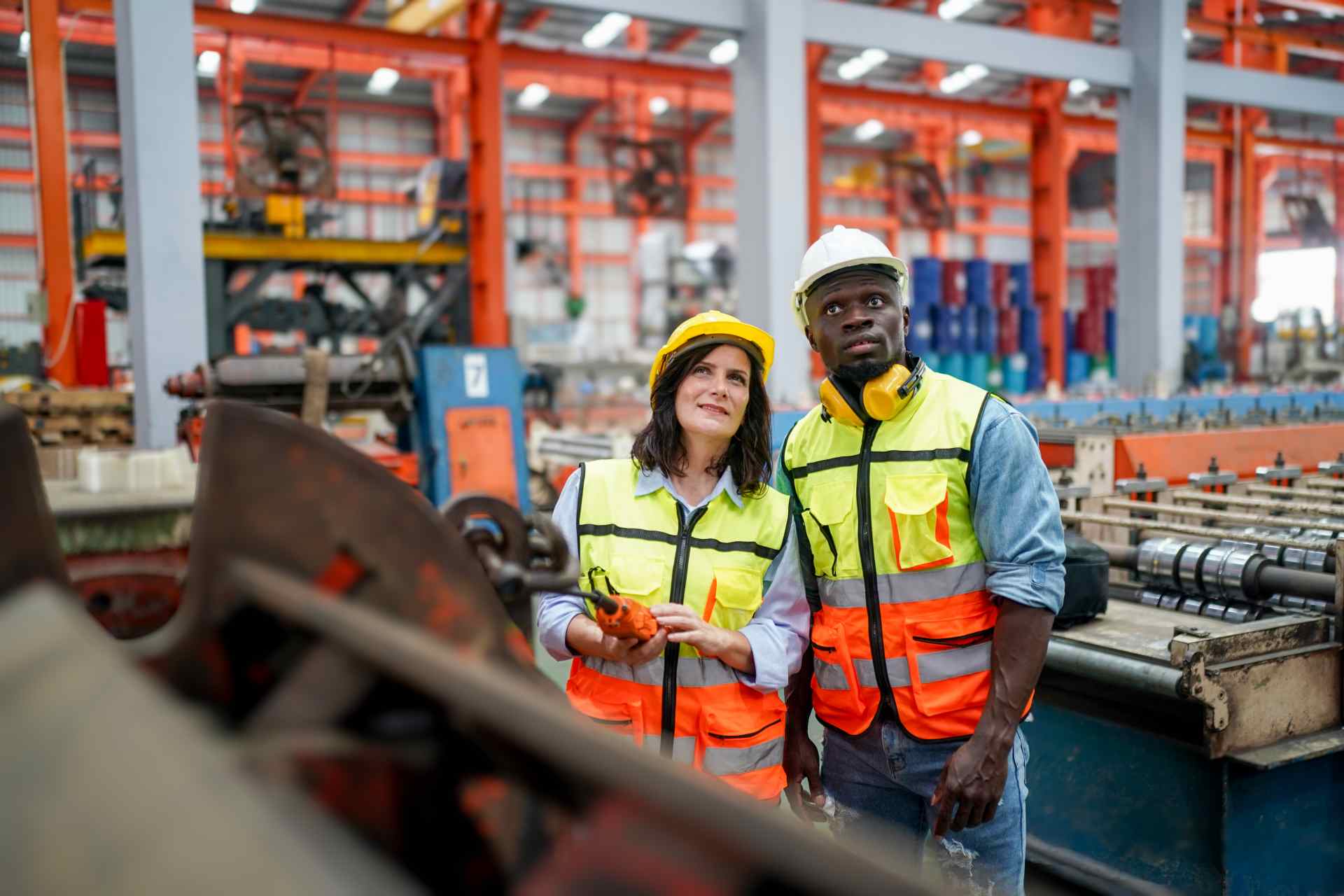 Two industrial workers examining machinery